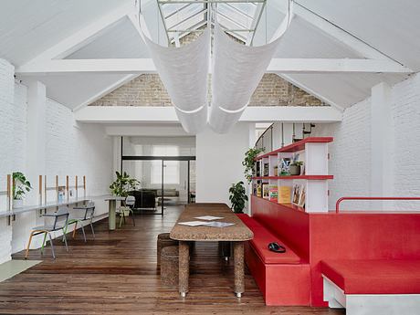 Bright, open-concept workspace with exposed brick walls, high ceilings, and modern furniture.