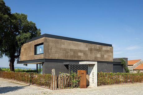 Modern multi-story house with mix of brick, wood, and sleek black accents.