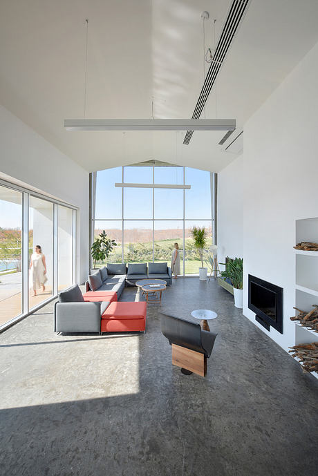 Expansive living room with modern furniture, large windows, and a minimalist ceiling design.