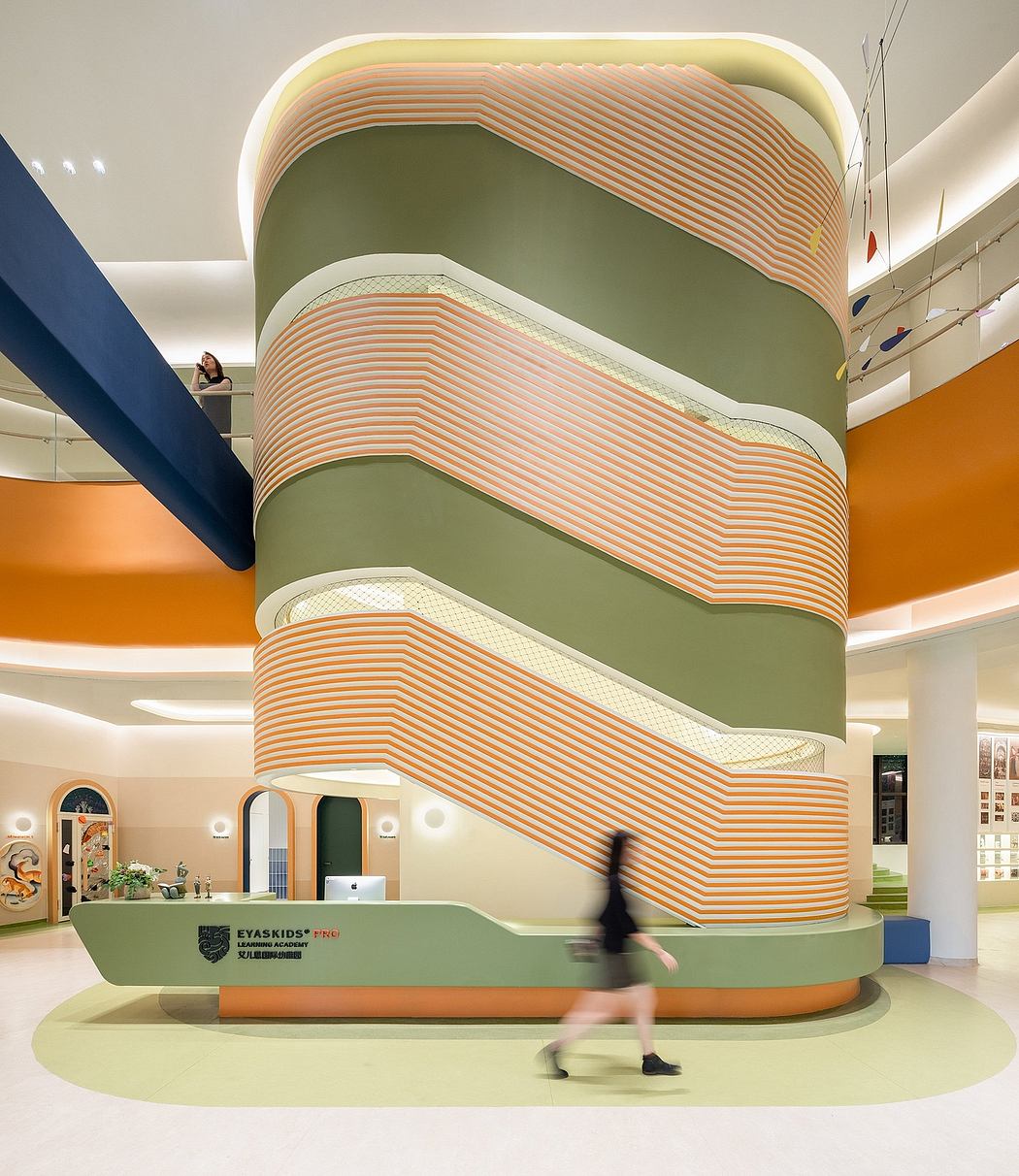 Vibrant, undulating architectural forms in warm hues create a dynamic, playful interior space.