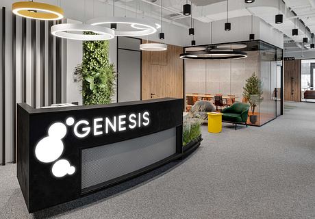 Modern office lobby with sleek black reception desk, suspended circular lights, and lush greenery.