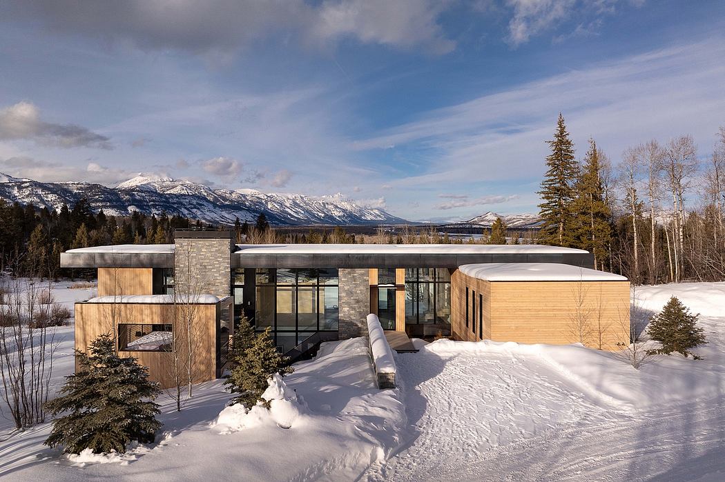 A modern, geometric mountain home with wood and stone accents, surrounded by snowy landscape.