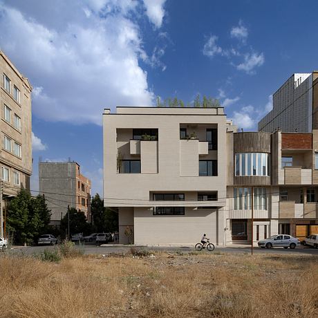 Modern multi-story building with clean lines, balconies, and varied facade materials.