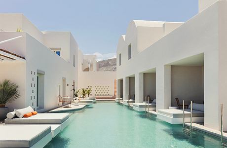 A serene contemporary courtyard with a rectangular pool surrounded by minimalist architecture.