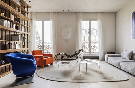 Spacious room with wood shelving, colorful furniture, and modern decorative elements.