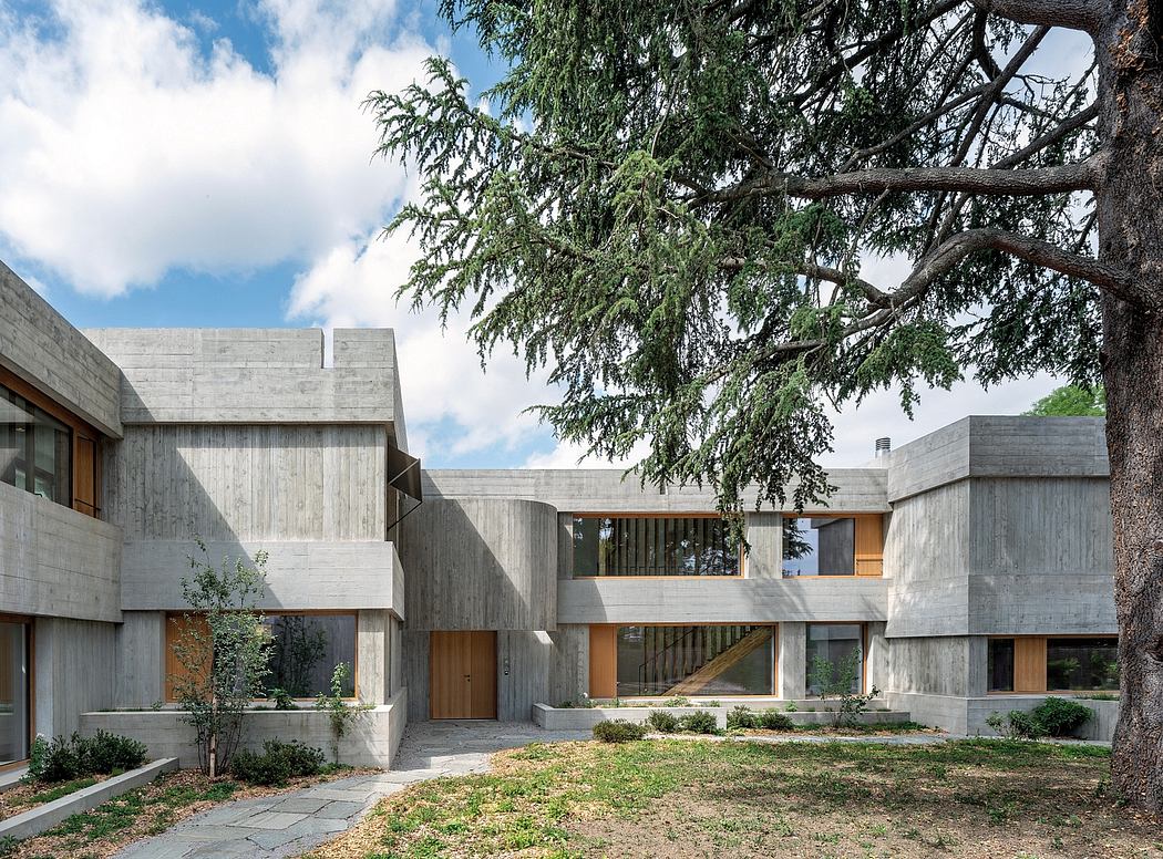 A modernist concrete residential complex with wood accents and lush surrounding greenery.