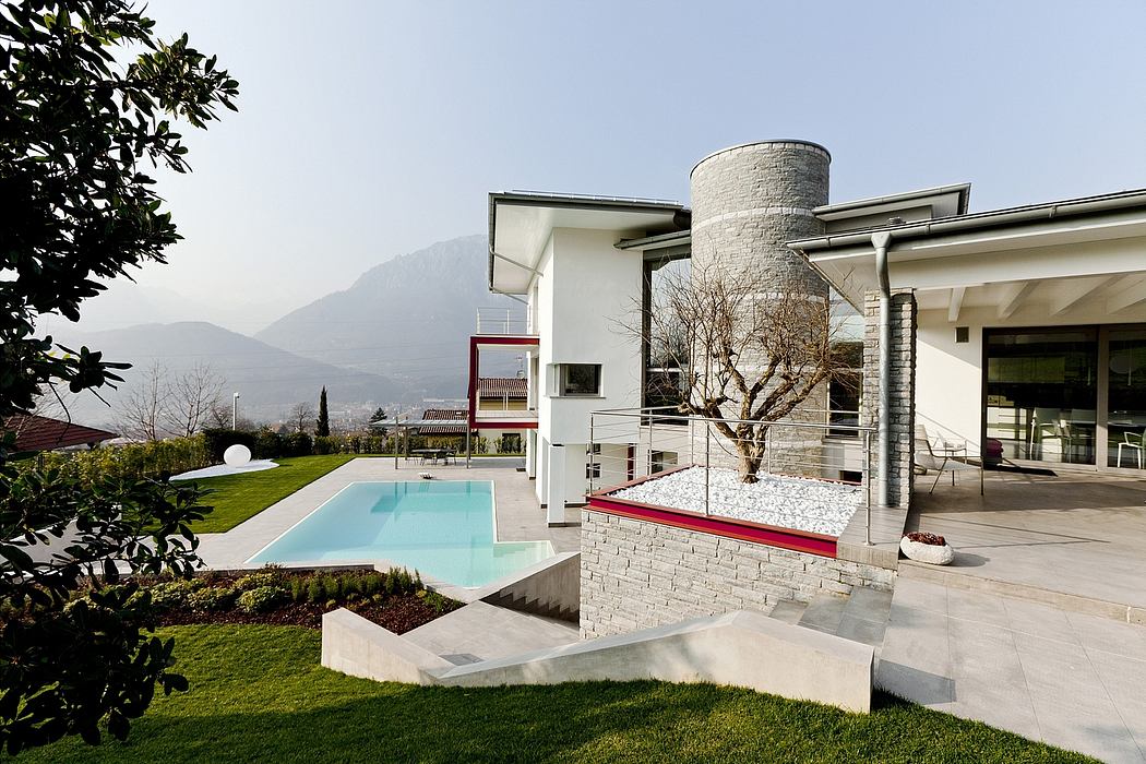 Striking modern home with pool, landscaped gardens, and stone tower feature.