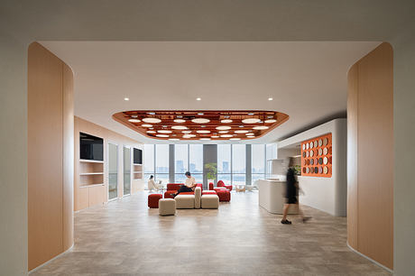 Spacious modern office interior with geometric lighting fixture and minimalistic furnishings.