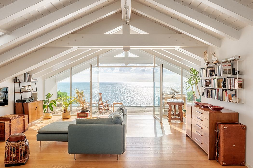 Spacious, airy living room with vaulted ceiling, large windows overlooking the ocean.