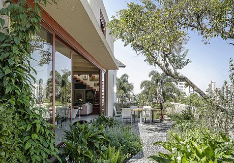 Modern tropical house with lush, green landscaping and an open living space.