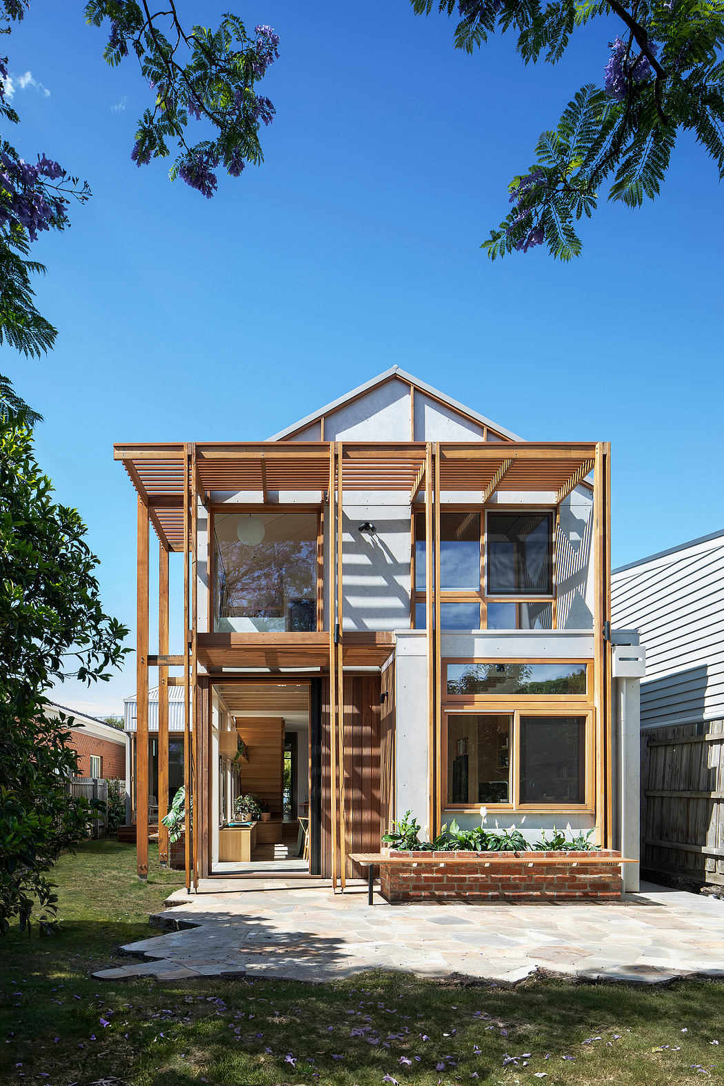 A modern home with wooden framing, large windows, and a covered porch. The exterior features a mix of natural materials and a minimalist design.