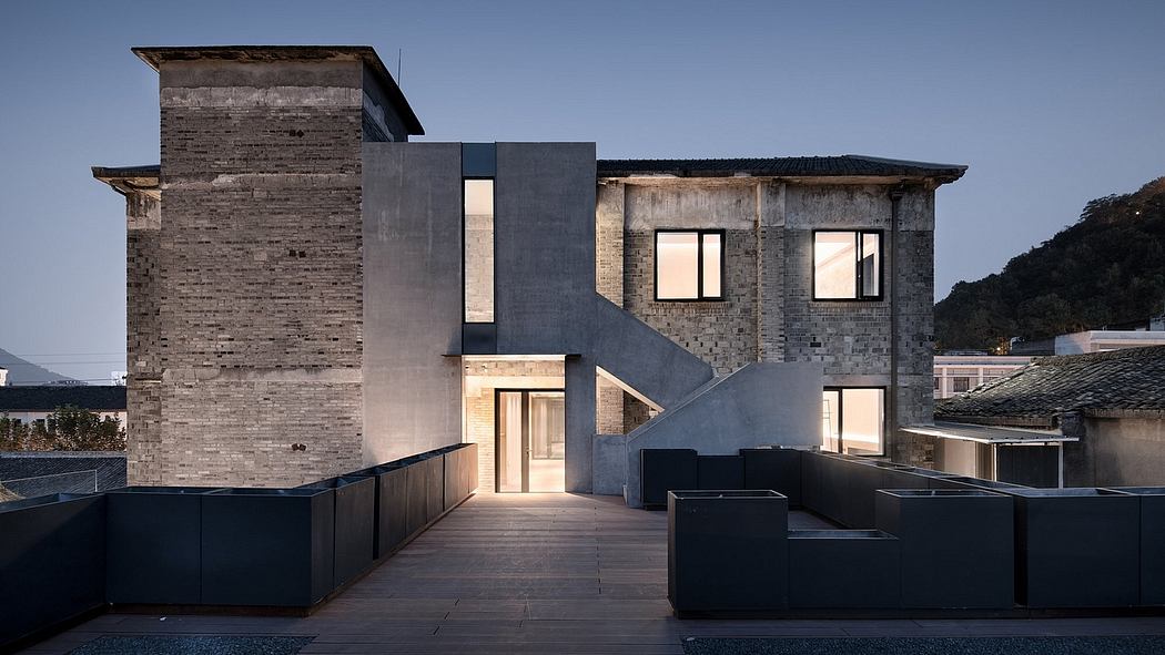 A modern, multi-level residential building with brick and concrete façade, rooftop terrace.