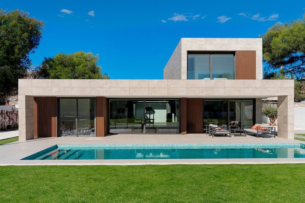 Modern single-story home with clean lines, glass walls, and a rectangular pool.