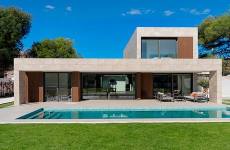 Modern single-story home with clean lines, glass walls, and a rectangular pool.