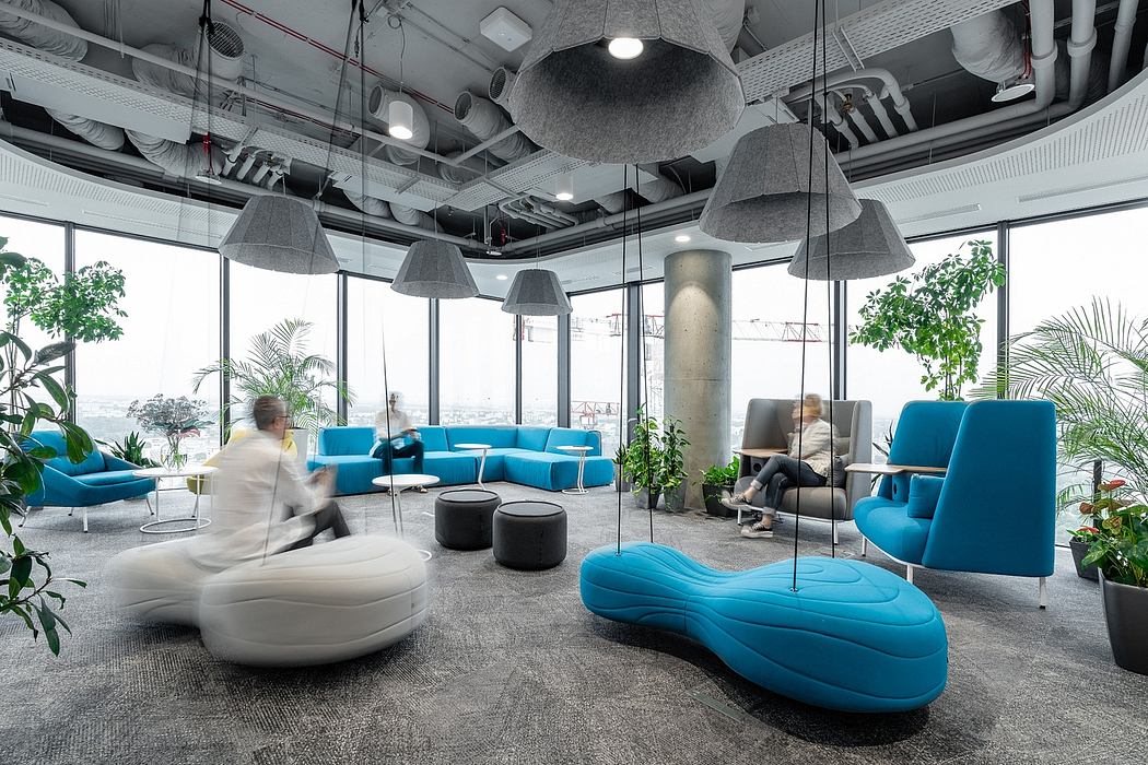 Modern office lounge with minimalist decor, vibrant blue furniture, and lush greenery.