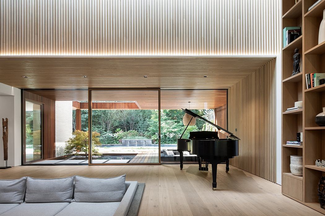 Minimalist living room with wooden paneled walls, floor-to-ceiling windows, and a grand piano.