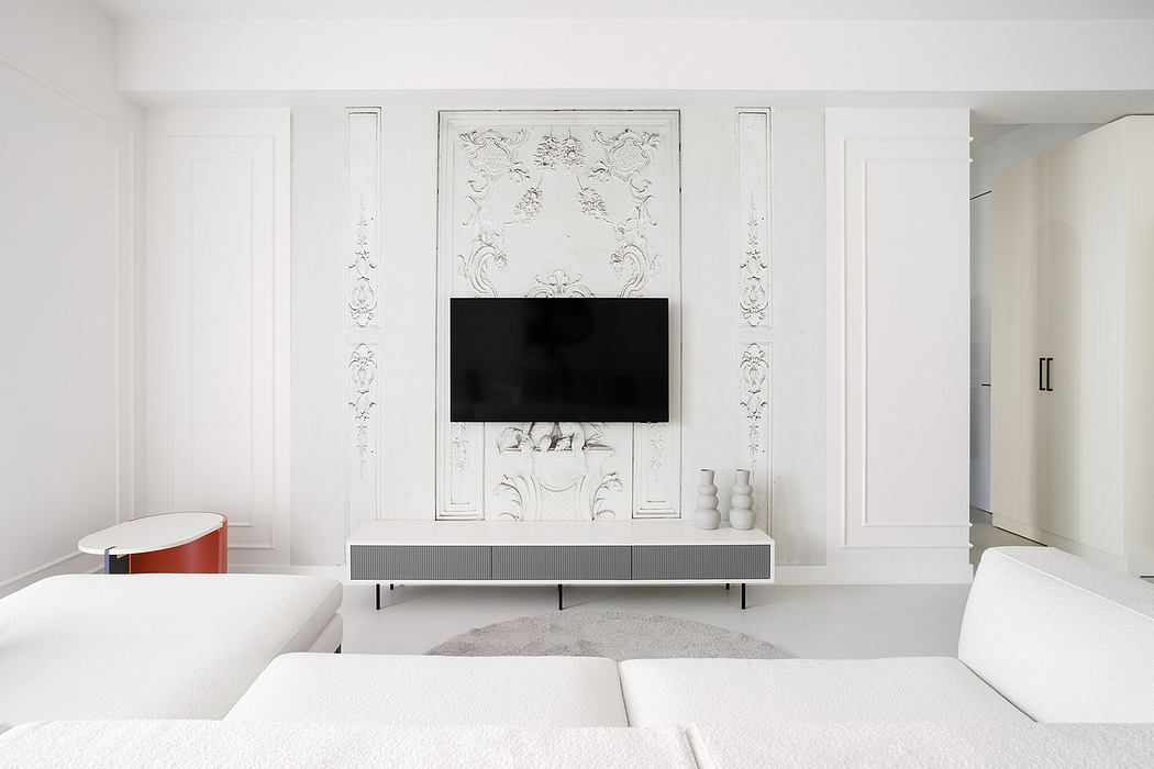 An elegant, minimalist living room with ornate architectural details and a sleek TV console.