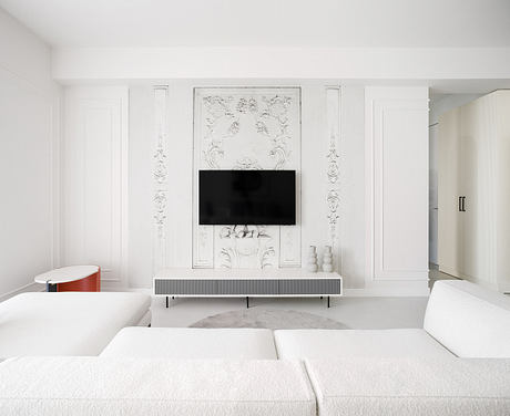 An elegant, minimalist living room with ornate architectural details and a sleek TV console.