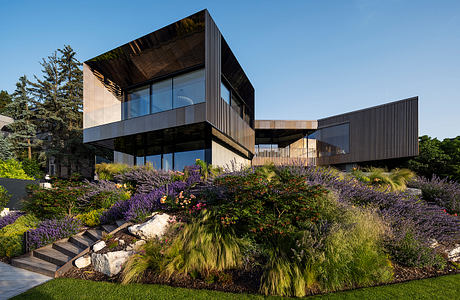 Striking modern architecture with glass walls, bold cantilevering, and lush landscaping.