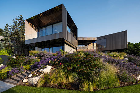 Striking modern architecture with glass walls, bold cantilevering, and lush landscaping.