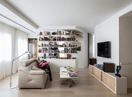 Cozy living room with built-in bookshelves, wooden TV stand, and minimal decor.