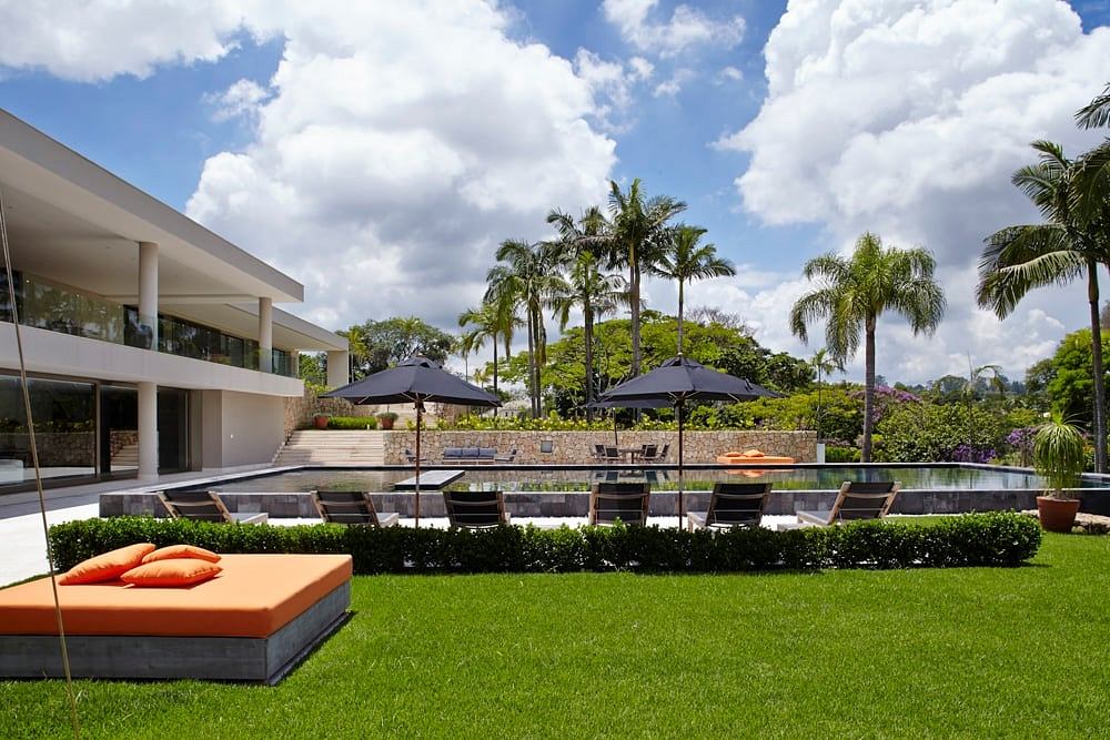 Serene outdoor lounge area with palm trees, umbrellas, and a sleek modern pool.