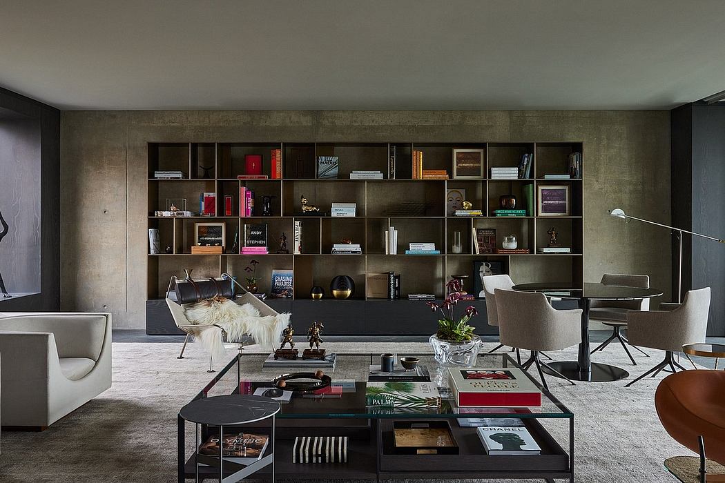 A modern and minimalist living room with concrete walls, custom shelving, and sleek furnishings.