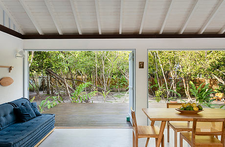 Cozy modern interior with large windows overlooking a lush outdoor garden.