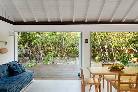 Cozy modern interior with large windows overlooking a lush outdoor garden.