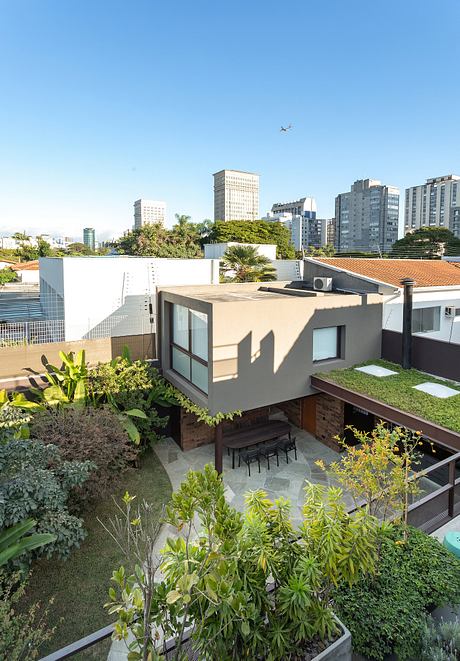 Lush rooftop garden with sleek modern structure, surrounded by city skyline.