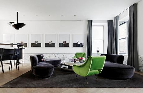 Sleek, modern living space with plush velvet seating, marble accents, and framed artwork.