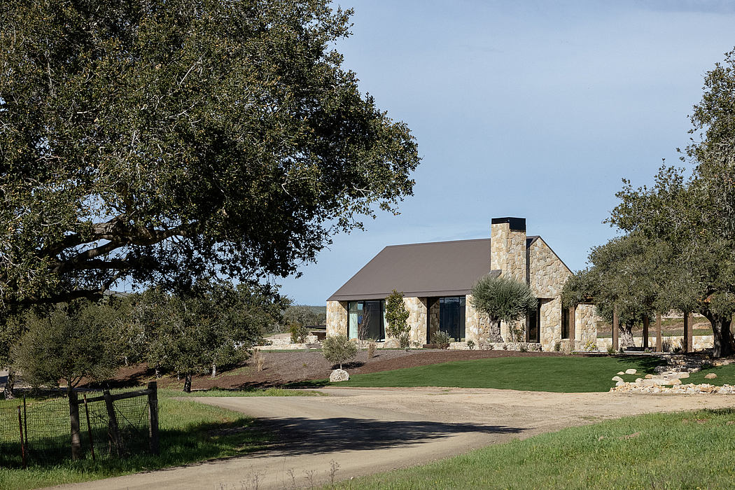 Rustic stone exterior with a sloping roof and large windows overlooking a grassy yard.