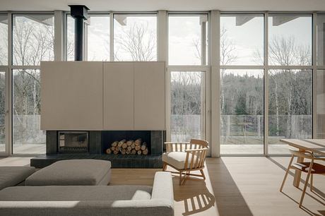 Spacious living room with large windows, sleek fireplace, and minimalist furniture.