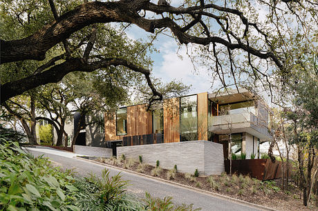 Modern luxury apartment complex nestled among lush green trees, featuring clean lines and natural materials.