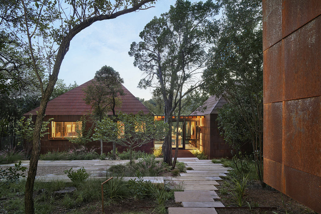 A modern, nature-inspired home with striking roofs, wooden exteriors, and a tranquil garden path.