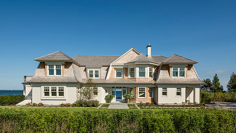 Ornate, multi-level beachfront home with dormers, gables, and expansive windows.