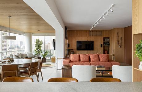 Cozy living space featuring warm wood accents, large sofa, and track lighting.