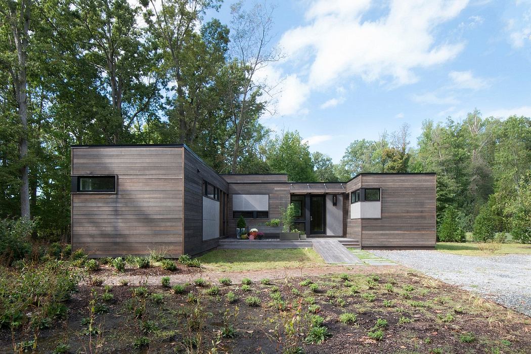 Modern wood-clad home with asymmetrical volumes, large windows, and a covered porch.