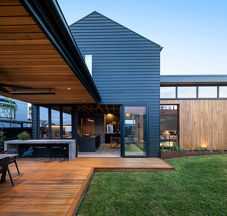 Contemporary wooden patio with glass walls, integrated outdoor area, and landscaped yard.