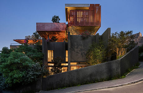 Striking modern architecture with intricate metal lattices, balconies, and lush greenery.