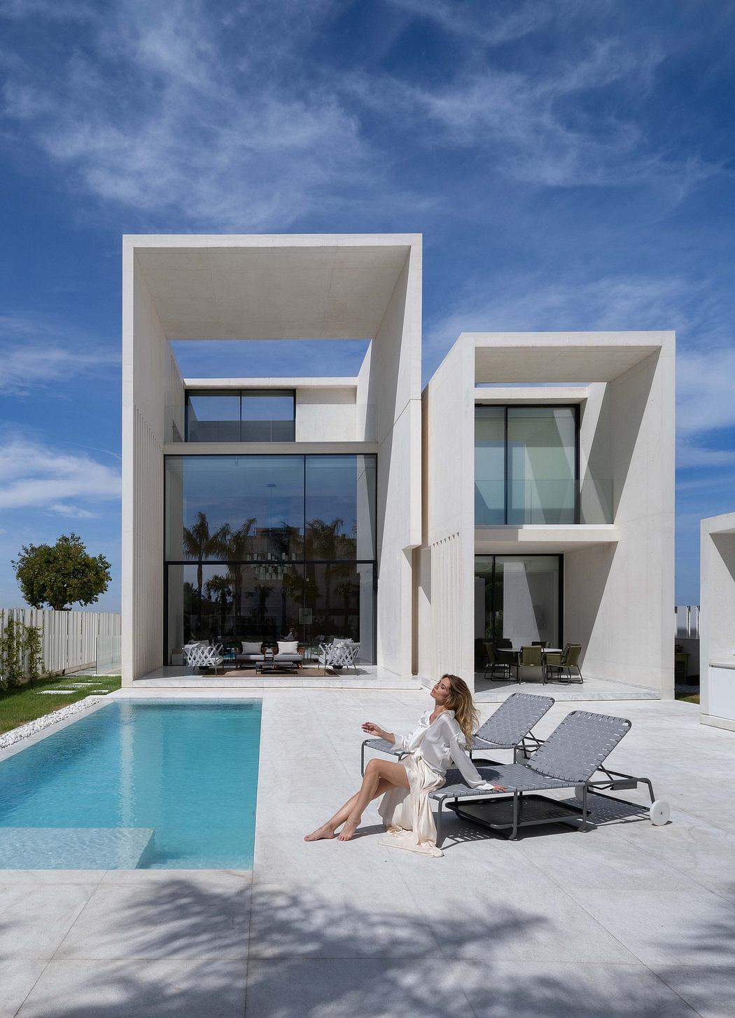 Sleek, modern architecture with clean lines, expansive glass panels, and a serene pool.