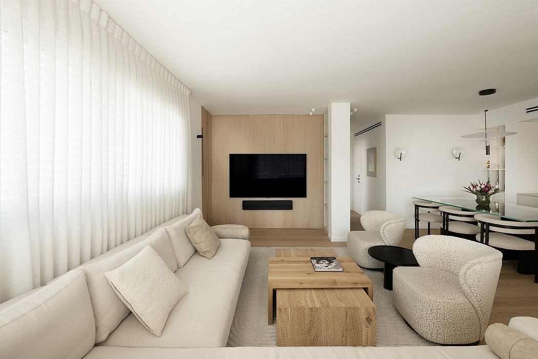 Minimalist living room with neutral tones, wood-paneled TV wall, and modern furniture.