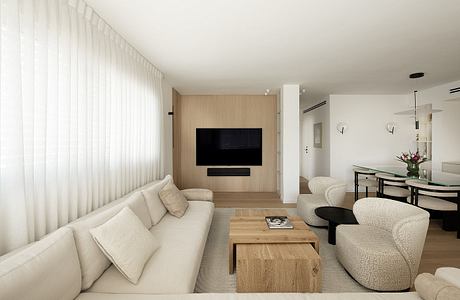 Minimalist living room with neutral tones, wood-paneled TV wall, and modern furniture.