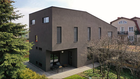 Striking modern exterior with clean lines, large windows, and a courtyard.