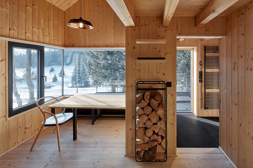 Cozy wood-paneled cabin with floor-to-ceiling windows, rustic furnishings, and fireplace.