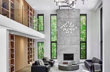 A modern, minimalist living space with a striking granite fireplace and an eye-catching chandelier.