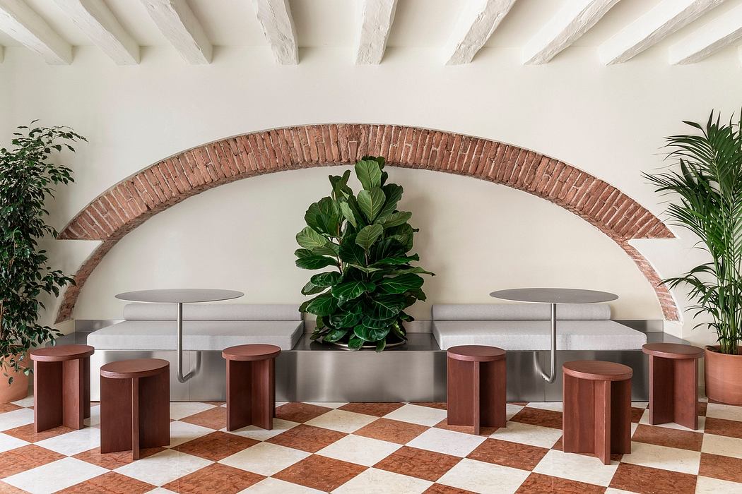 Elegant brick archway frames a modern seating area with potted plants.