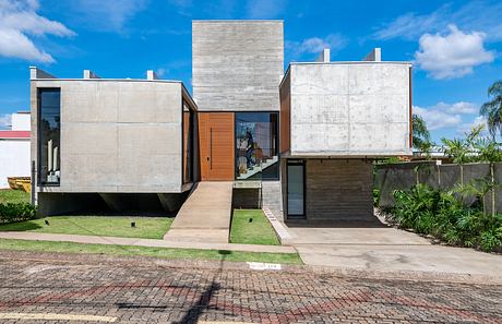 Modernist concrete and wood architecture with palm trees in the foreground.