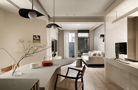 Modern, minimalist living room with sleek furniture, pendant lights, and wood floors.