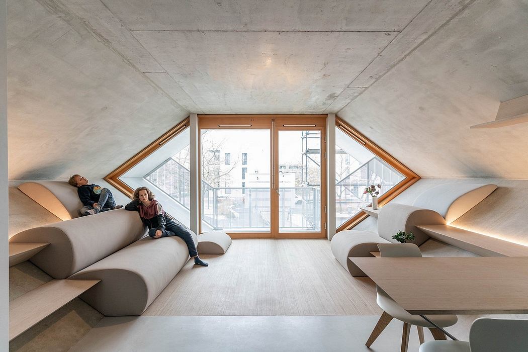 Striking attic space with angled windows, plush seating, and minimalist furnishings.